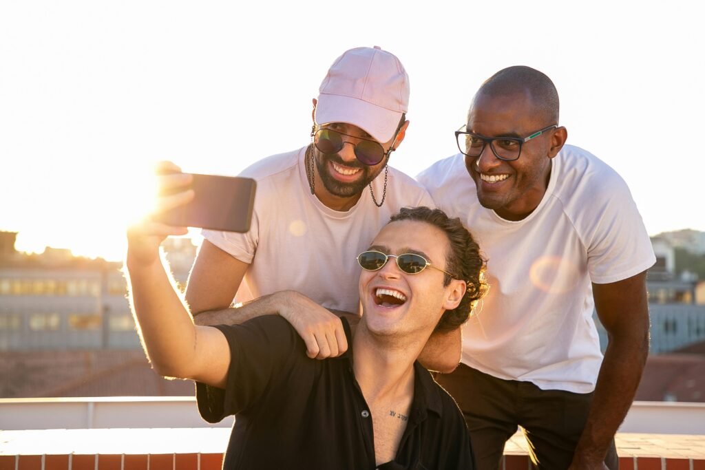 Three friends enjoying a sunny day and taking a selfie on a rooftop terrace.